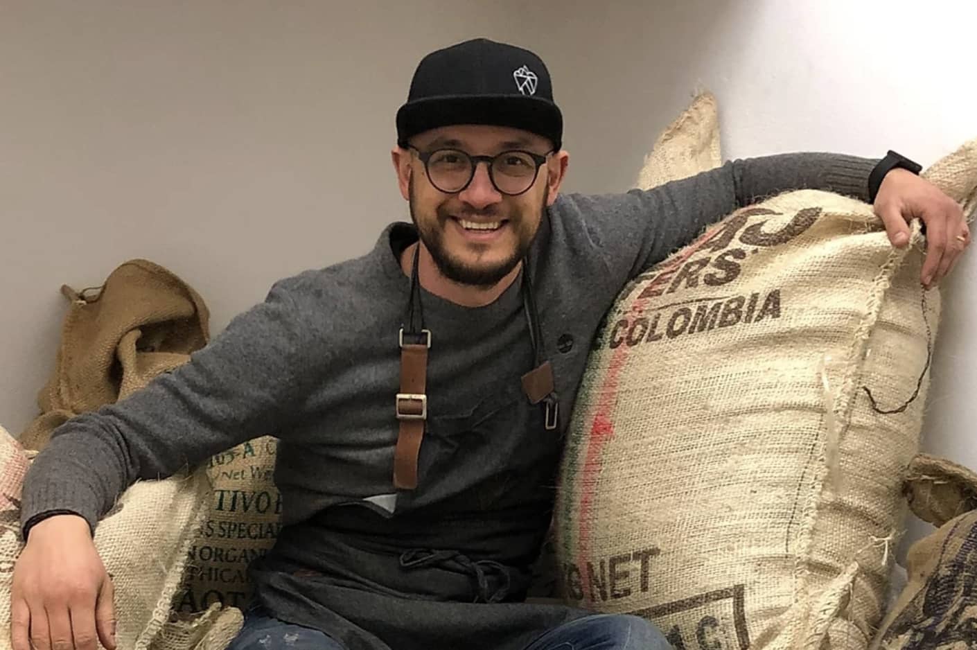 federico from lim sitting on bags of cocoa bean