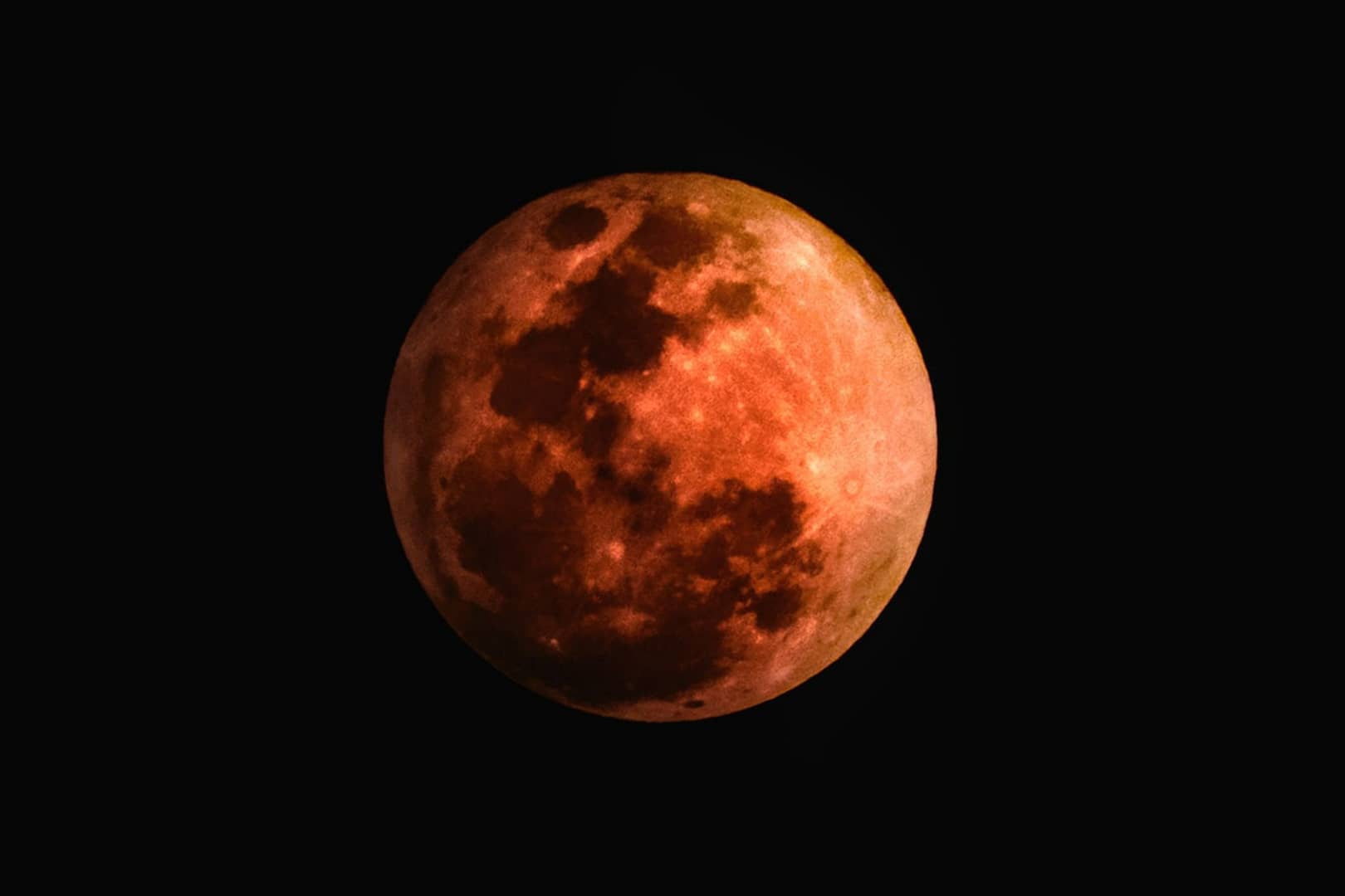 red orange moon on a black background