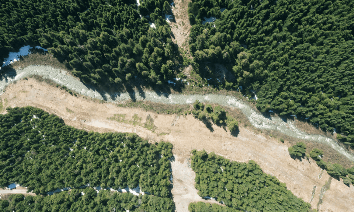 aerial photograph of a river flowing through a forest near whistler in canada