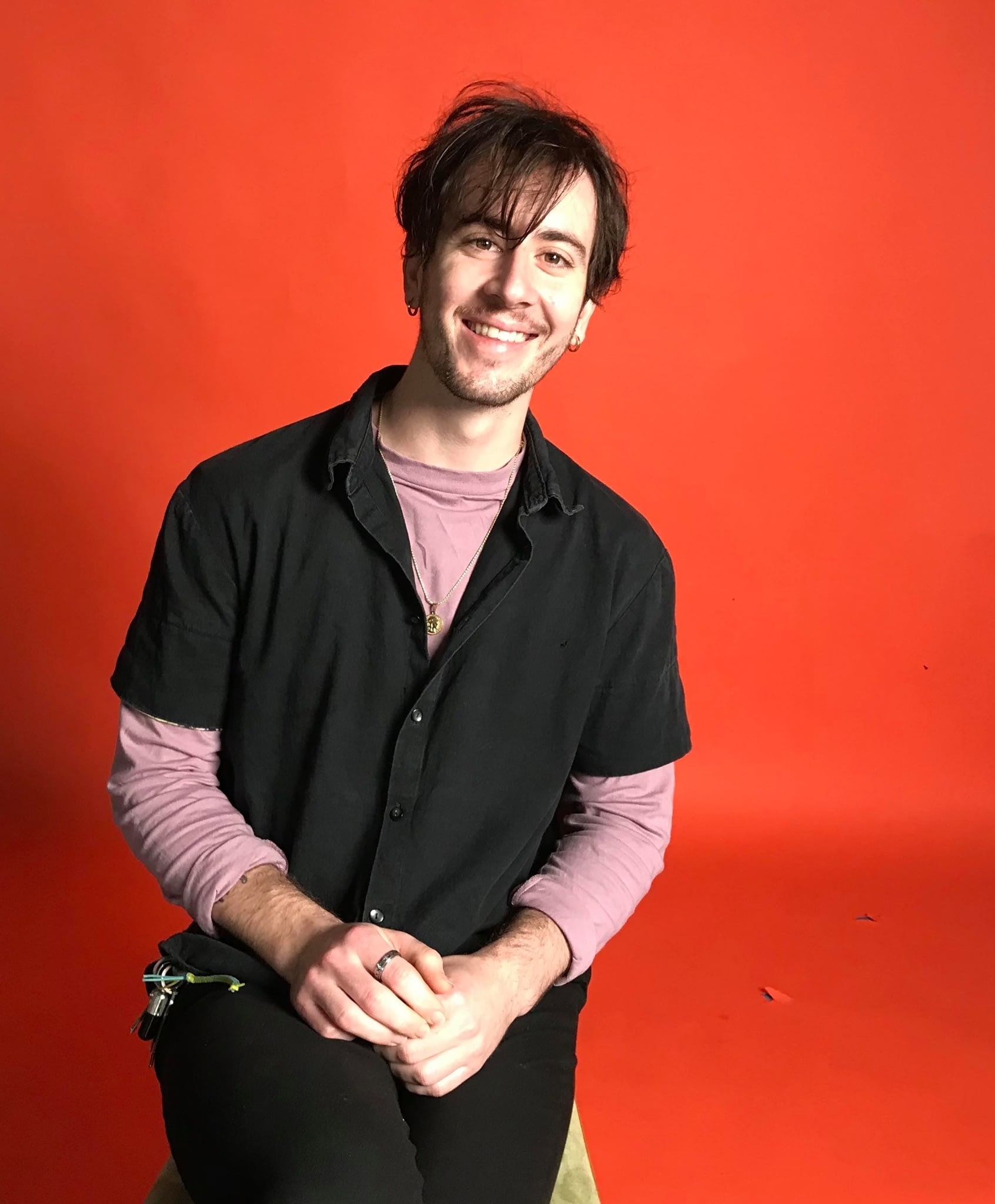 James sitting in front of an orange background